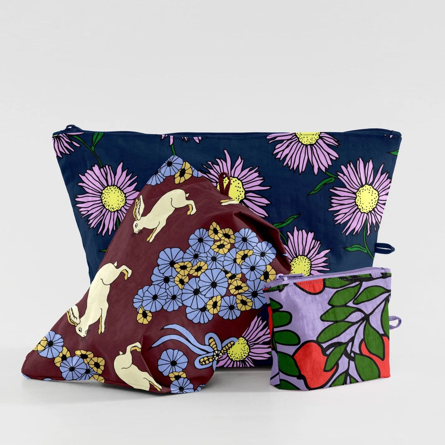 Three colorful pouches with floral and animal designs on a white background