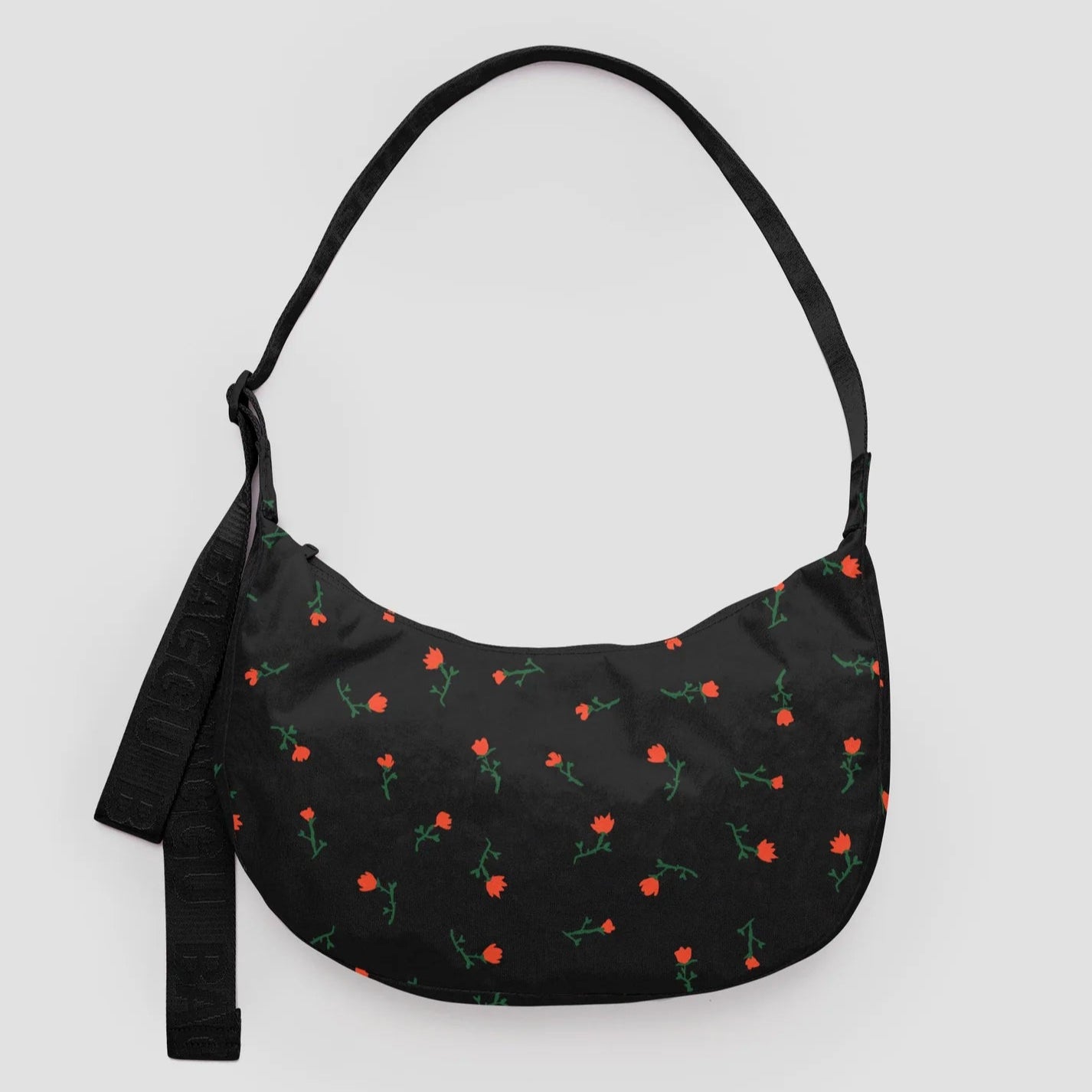Black shoulder bag with floral pattern on a light gray background