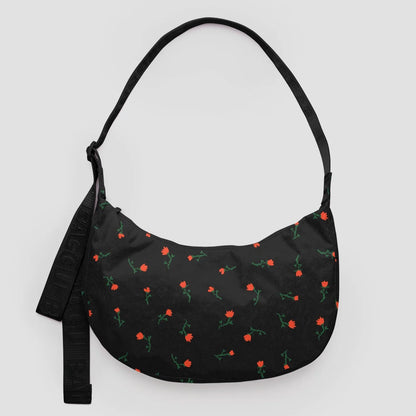 Black shoulder bag with floral pattern on a light gray background