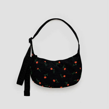 Black handbag with floral pattern on a light gray background
