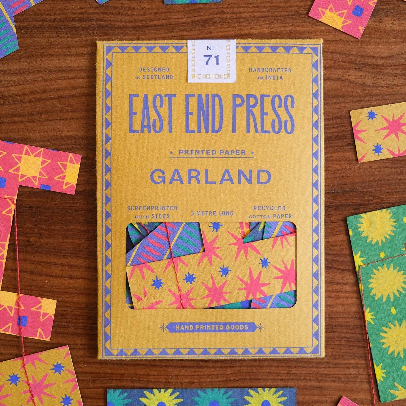 Package of East End Press Garland printed paper with colorful letters on a wooden surface