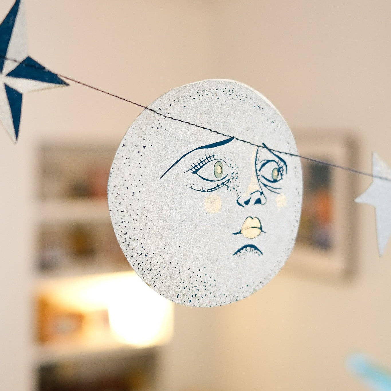 Decorative banner with moon and star designs hanging in a room.